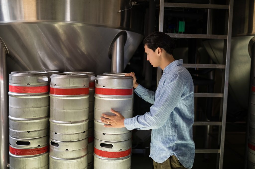 Manager checking beer keg in warehouse